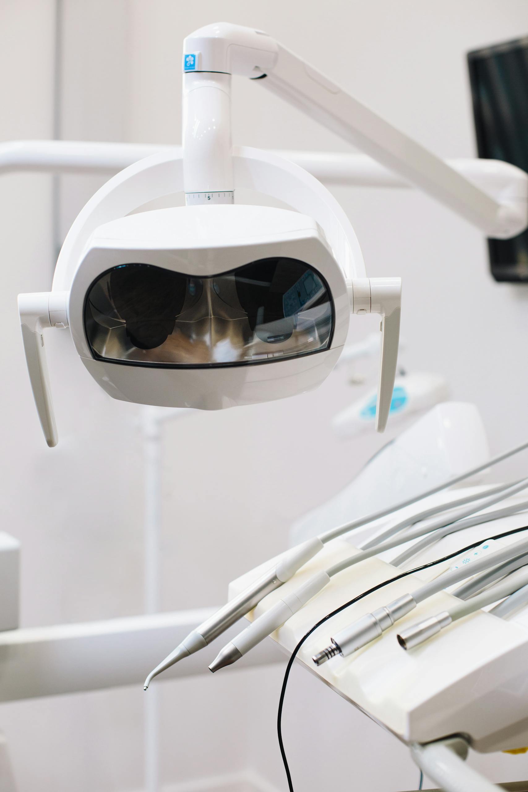 Close-up of dental equipment with bright lighting and instruments in a clinic.